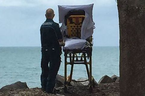 Ein letzter Blick aufs Meer: Ein Mitarbeiter des Queensland Ambulance Service mit der Patientin