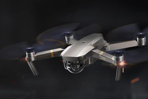 Die Drohne DJI Mavic Pro hängt vor einem dunklen Hintergrund in der Luft