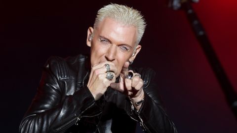 H.P. Baxxter von Scooter steht auf der Bühne und singt. Mit der rechten Hand hält er sich ein Mikrofon vor den Mund