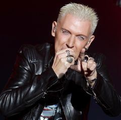 H.P. Baxxter von Scooter steht auf der Bühne und singt. Mit der rechten Hand hält er sich ein Mikrofon vor den Mund