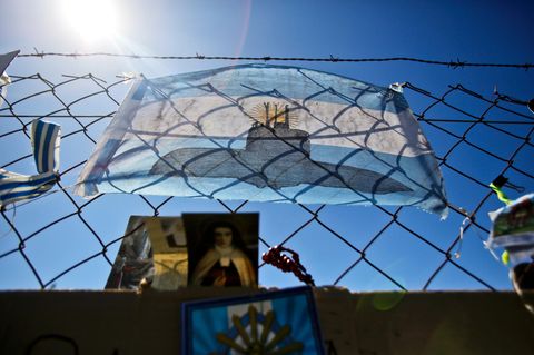 Eine argentinische Fahne mit dem Bild eines U-Boots hängt am Zaun der Marinebasis in Mar del Plata.