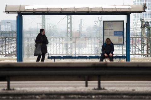 Ein Mann sitzt an einer Bushaltestelle - Die Stadt Düsseldorf hat dafür 35 Euro Strafe verhängt