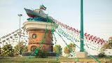Ein ausrangiertes Patrouillenboot thront auf einem Denkmal, mitten auf einer Verkehrsinsel in Buschehr, einer Hafenstadt am Persischen Golf.