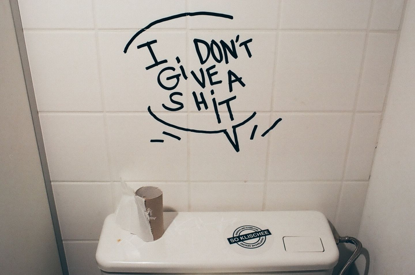 Über einer Toilette steht der Spruch "I don't give a shit"