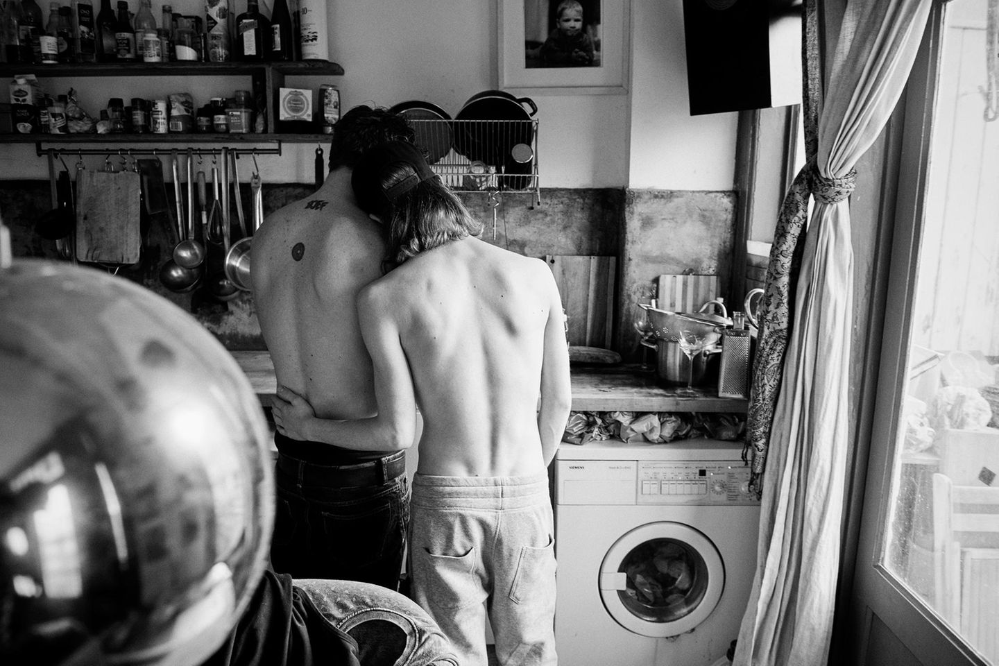 Mitten in der Küche einer Wohnung umfasst das junge Paar Boris und David