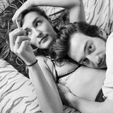 Ein junges Paar liegt kuschelnd auf einer Couch