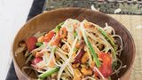 Som Tam – grüne-Papaya-Salat aus Thailand      Zutaten:    500 g grüne Papaya (aus dem Asia-Laden), 5 EL Erdnüsse, 3 große Knoblauchzehen, 3–4 Thai-Chili-Schoten (nach Belieben mehr), 3 EL getrocknete kleine Shrimps (aus dem AsiaLaden), 100 g Schlangenbohnen, Salz, 150 g Cocktailtomaten, 4 EL Fischsauce, plus mehr zum Abschmecken, 2 EL Limettensaft, plus mehr zum Abschmecken, 2 EL Palmzucker, plus mehr zum Abschmecken      Zubereitung:    Klassisch werden alle Zutaten für den Papaya-Salat in einem sehr großen Mörser miteinander vermischt.  Wer keinen sehr großen Mörser hat, stampft am besten die kleinen Zutaten miteinander und mischt die Masse anschließend in einer Schüssel mit den Papaya-Raspeln.        Die Papaya schälen, Fäden und Kügelchen in der Mitte entfernen und das Fruchtfleisch in lange dünne Streifen raspeln. Die Erdnüsse in einer Pfanne ohne Fett rösten, bis sie Farbe annehmen und beiseitestellen. Den Knoblauch abziehen und fein hacken. Die Chilischoten waschen, abtupfen und mit dem Knoblauch in einem großen Mörser zerreiben. Die getrockneten Shrimps zugeben und mit dem Stößel grob zerkleinern. Die Schlangenbohnen putzen, in mundgerechte Stücke schneiden und in Salzwasser etwa 3 Minuten blanchieren. Abgießen und mit der Hälfte der Erdnüsse im Mörser verarbeiten, die Bohnen aber nur leicht zerdrücken.        Die Cocktailtomaten waschen, trockentupfen, halbieren und im Mörser leicht zerdrücken, bis Saft austritt.        Alles in eine Schüssel umfüllen, mit Fischsauce, Limettensaft und Palmzucker würzen und alles vermischen. Vorsichtig die Papaya-Raspeln untermischen. Bei Bedarf nochmals mit Fischsauce, Palmzucker oder Limettensaft nachwürzen und mit den restlichen Erdnüssen anrichten.