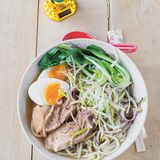 Ramen-Nudeln mit Schweineschulter, weichem Ei und Pak Choi      Zutaten für 4 Personen:  2 Karotten, 1 Stange Lauch, 1/4 Knolle Sellerie, 1 große Zwiebel, 400 g Schweineknochen (vom Metzger), 500 g Schweineschulter, 1 Kombu-Alge (etwa 10 x 10 cm aus dem Asialaden) 5 cm frischer Ingwer, in Scheiben geschnitten, 5 Knoblauchzehen, abgezogen, 4 Eier, 2 Frühlingszwiebeln, 2 EL Miso-Pasta, 3 EL Sojasauce, Salz, 400 g Ramen-Nudeln, 4 kleine Pak Choi, 150 g frische Sojasprossen, Chilipulver zum Bestauben        Zubereitung:  Karotten, Lauch und Sellerie putzen, in grobe Stücke schneiden, die Zwiebel samt der Schale halbieren. Mit Knochen und Schweineschulter in 3 l kaltem Wasser zum Kochen bringen. Eventuell entstehenden Schaum abschöpfen und die Temperatur reduzieren, sodass die Brühe nur noch leicht vor sich hin köchelt. Kombu-Alge, Ingwer und Knoblauch zugeben und alles etwa 2 Stunden köcheln lassen, bis die Schweineschulter zart ist. Das kann je nach Fleisch variieren.  Währenddessen die Eier 7 Minuten kochen und kalt abschrecken. Die Frühlingszwiebel putzen und der Länge nach in dünne Streifen schneiden.  Wenn das Fleisch weich ist, die Brühe durch ein Sieb abgießen. Die Miso-Paste in die Brühe rühren, mit Sojasauce und Salz abschmecken. Das Fleisch in Scheiben schneiden und in der Brühe warm halten.  Die Ramen-Nudeln nach Packungsangabe in Salzwasser weich kochen und abgießen. Den Pak Choi putzen, halbieren und kurz vor dem Servieren in die heiße Brühe zum Fleisch geben.  Zum Servieren Nudeln, Pak Choi, Fleisch und die halbierten Eier in tiefen Schalen anrichten. Brühe angießen, Sojasprossen und Frühlingszwiebel darauf verteilen und nach Belieben mit Chilipulver bestauben.