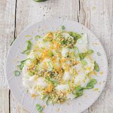 Ceviche      Zutaten:  1 unbehandelte Orange, 5 unbehandelte Limetten, 1 Schalotte, 1 Knoblauchzehe, 1 Scheibe frischer Ingwer (etwa 0,5 cm), 1 kleine Chilischote, 4 Zweige Koriander, 2 Zweige Minze, 4 EL Olivenöl, Salz, 2 Frühlingszwiebeln, 600 g Wolfsbarsch oder ein anderes weißes Fischfilet      Zubereitung:  Die Schale von der Orange und von 2 Limetten abreiben und beiseitestellen. Von der Orange und allen Limetten den Saft auspressen. Schalotte und Knoblauch abziehen und sehr fein würfeln. Den Ingwer schälen und sehr fein hacken oder reiben. Die Chilischote waschen, abtupfen, von Stielansatz und Samen befreien und fein schneiden.         Koriander und Minze waschen und trockenschütteln. Den Koriander mit Stängeln, von der Minze die abgezupften Blätter fein hacken und mit Ingwer, Knoblauch, Schalotten und Chili in eine Schüssel geben. Mit dem Saft der Orange und der Limetten sowie dem Olivenöl vermengen und mit Salz abschmecken. Die Frühlingszwiebel putzen und in dünne Ringe schneiden.         Den frischen Fisch schräg zur Faser sehr dünn aufschneiden und die Scheiben auf eine große Platte oder mehrere Teller verteilen.         Unmittelbar vor dem Servieren mit der Marinade übergießen und Orangen- und Limettenschale sowie die Frühlingszwiebelringe darüber verteilen.