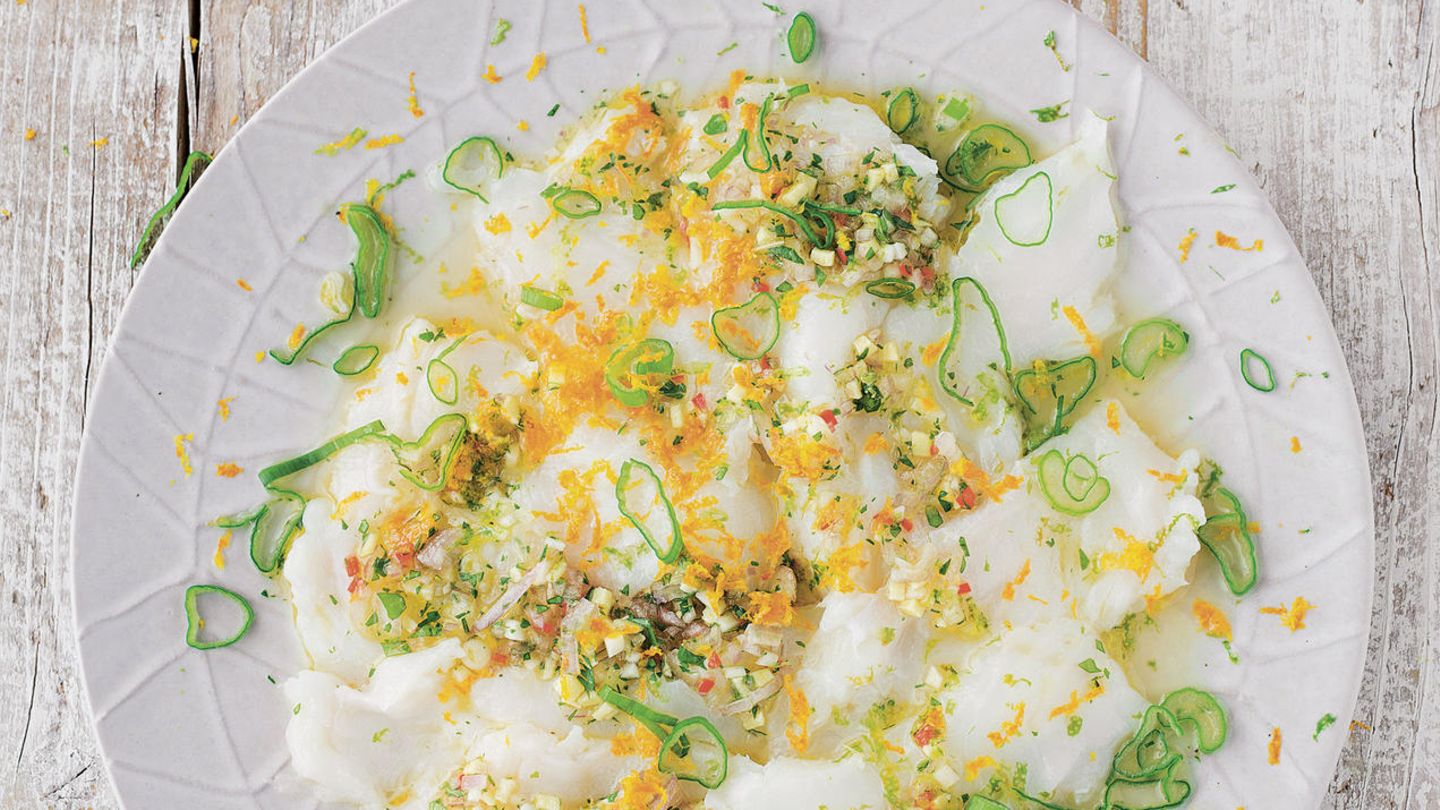 Ceviche      Zutaten:  1 unbehandelte Orange, 5 unbehandelte Limetten, 1 Schalotte, 1 Knoblauchzehe, 1 Scheibe frischer Ingwer (etwa 0,5 cm), 1 kleine Chilischote, 4 Zweige Koriander, 2 Zweige Minze, 4 EL Olivenöl, Salz, 2 Frühlingszwiebeln, 600 g Wolfsbarsch oder ein anderes weißes Fischfilet      Zubereitung:  Die Schale von der Orange und von 2 Limetten abreiben und beiseitestellen. Von der Orange und allen Limetten den Saft auspressen. Schalotte und Knoblauch abziehen und sehr fein würfeln. Den Ingwer schälen und sehr fein hacken oder reiben. Die Chilischote waschen, abtupfen, von Stielansatz und Samen befreien und fein schneiden.         Koriander und Minze waschen und trockenschütteln. Den Koriander mit Stängeln, von der Minze die abgezupften Blätter fein hacken und mit Ingwer, Knoblauch, Schalotten und Chili in eine Schüssel geben. Mit dem Saft der Orange und der Limetten sowie dem Olivenöl vermengen und mit Salz abschmecken. Die Frühlingszwiebel putzen und in dünne Ringe schneiden.         Den frischen Fisch schräg zur Faser sehr dünn aufschneiden und die Scheiben auf eine große Platte oder mehrere Teller verteilen.         Unmittelbar vor dem Servieren mit der Marinade übergießen und Orangen- und Limettenschale sowie die Frühlingszwiebelringe darüber verteilen.