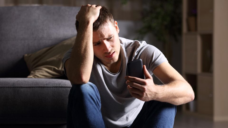 Mann schaut auf Telefon