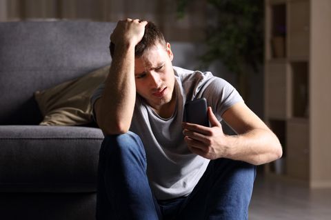 Mann schaut auf Telefon