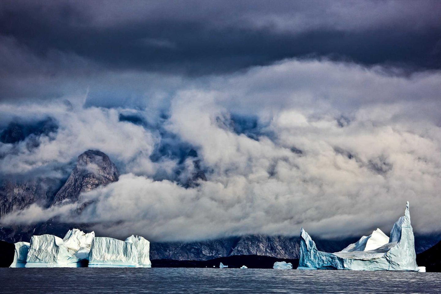 Im Bann des Nordens: Unterwegs im grönländischen Scoresbysund, dem längsten Fjordsystem der Welt. Im Wasser treiben mächtige Eisberge. Sie sind nicht ungefählich, lugen doch nur ihre Spitzen aus dem Wasser, während der größte Teil unter der Oberfläche lauert, was bekanntermaßen zu Fehleinschätzungen führen kann. Unterwegs im grönländischen Scoresbysund, dem längsten Fjordsystem der Welt. Im Wasser treiben mächtige Eisberge. Sie sind nicht ungefählich, lugen doch nur ihre Spitzen aus dem Wasser, während der größte Teil unter der Oberfläche lauert, was bekanntermaßen zu Fehleinschätzungen führen kann.
