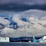 Unterwegs im grönländischen Scoresbysund, dem längsten Fjordsystem der Welt. Im Wasser treiben mächtige Eisberge. Sie sind nicht ungefählich, lugen doch nur ihre Spitzen aus dem Wasser, während der größte Teil unter der Oberfläche lauert, was bekanntermaßen zu Fehleinschätzungen führen kann.