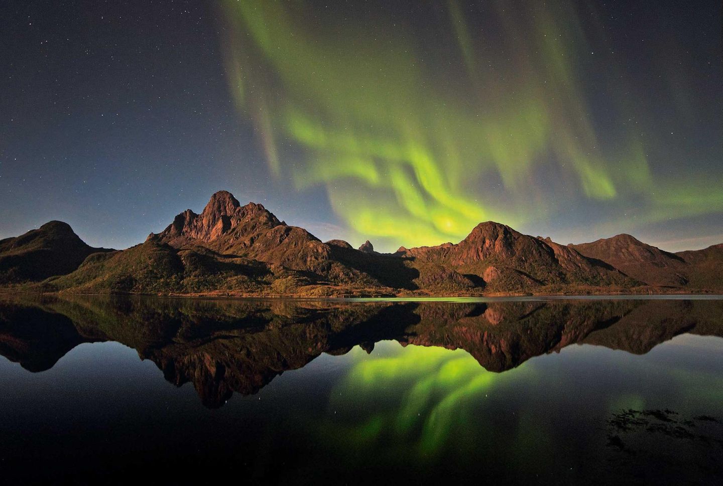 Die Stelle am Annfjord auf Langøya in Norwegen hatte Bernd Römmelt bei Tage ausgekundschaftet und blieb bis zur Nacht, auf Nordlichter hoffend. Er hatte Glück: Gegen 23 Uhr, der Vollmond schuf eine geradezu gespenstische Atmosphäre, begann das Leuchten.