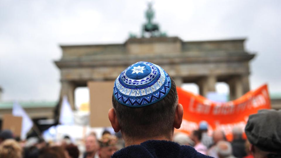 Ein Jude steht vor dem Brandenburger Tor in Berlin
