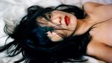 Eine asiatische Frau liegt auf einem Bett