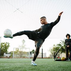 Fußballspieler kickt gegen Ball