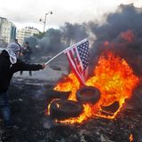Demonstranten zünden eine US-Flagge an