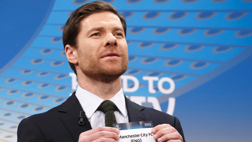 Ex-Fußballer Xavi Alonso hält ein Los mit "Manchester City" in den Händen