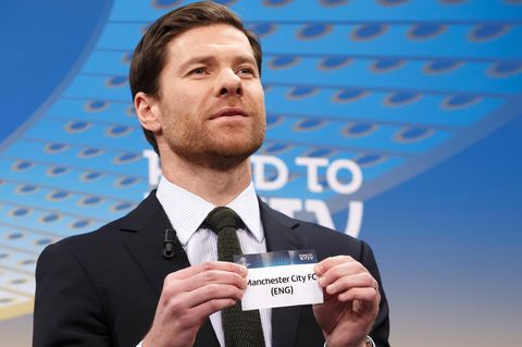 Ex-Fußballer Xavi Alonso hält ein Los mit "Manchester City" in den Händen