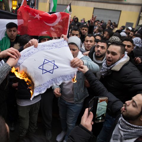 Pro-palästinensische Demonstranten verbrennen eine Israel-Flagge in Berlin