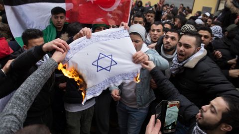 Pro-palästinensische Demonstranten verbrennen eine Israel-Flagge in Berlin