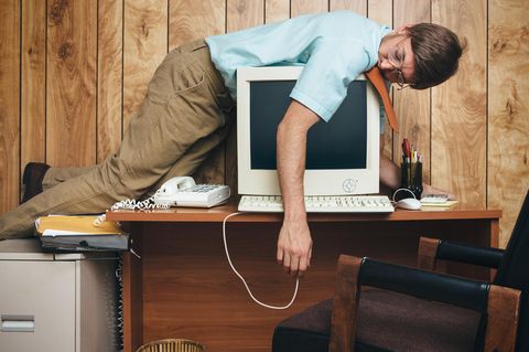 Mann liegt müde auf einem Computer