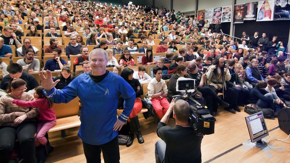 Voll besetzter Hörsaal bei der Star Trek Vorlesung Voll besetzter Hörsaal bei der Star Trek Vorlesung - Hubert Zitt im blauen Starfleet-Shirt zeigt den Vulkanier-Gruß