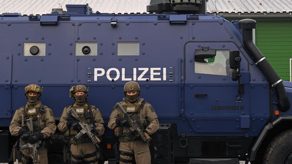 Bewaffnete Polizisten des SEK stehen während der Präsentation des neuen Panzerwagens "Survivor R" in Leipzig vor dem Fahrzeug