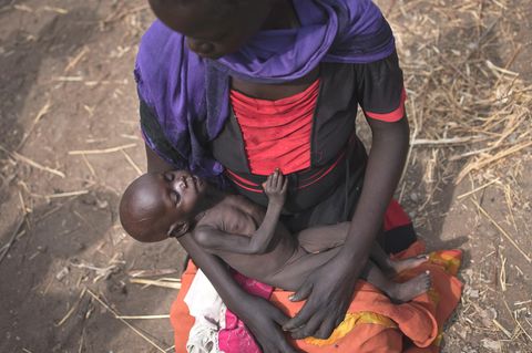 Eine Frau hält am Standort einer Essensausgabe in Malualkuel im Sudan ihre abgemagerte Tochter im Arm
