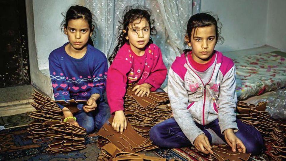 Syrische Mädchen stecken für Damensandalen Nieten in Laschen