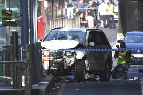 Ein Polizist fotografiert das Fahrzeug, mit dem ein Mann in Melbourne eine Menschenmenge gerast ist