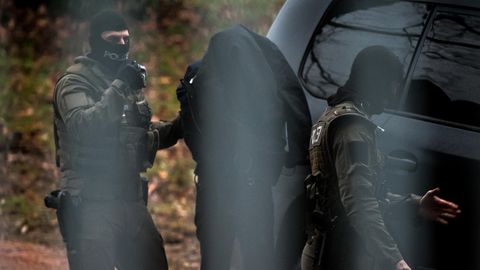 Polizisten begleiten in Karlsruhe einen Verdächtigen