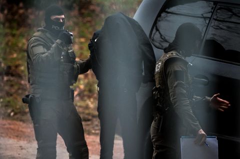 Polizisten begleiten in Karlsruhe einen Verdächtigen