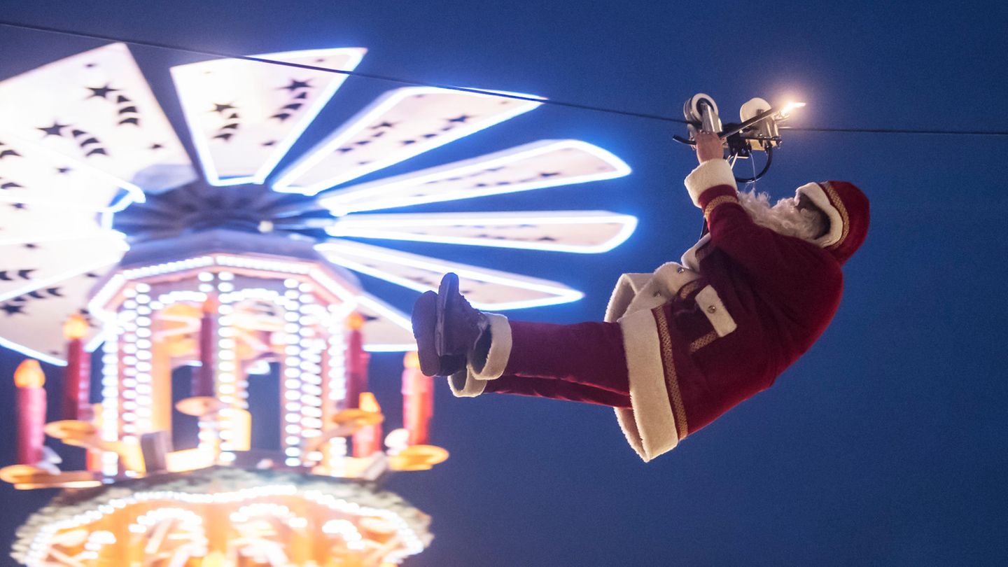 Der Hochseilartist Falko Traber seilt sich über dem Weihnachtsmarkt als Weihnachtsmann verkleidet von einem Dach ab