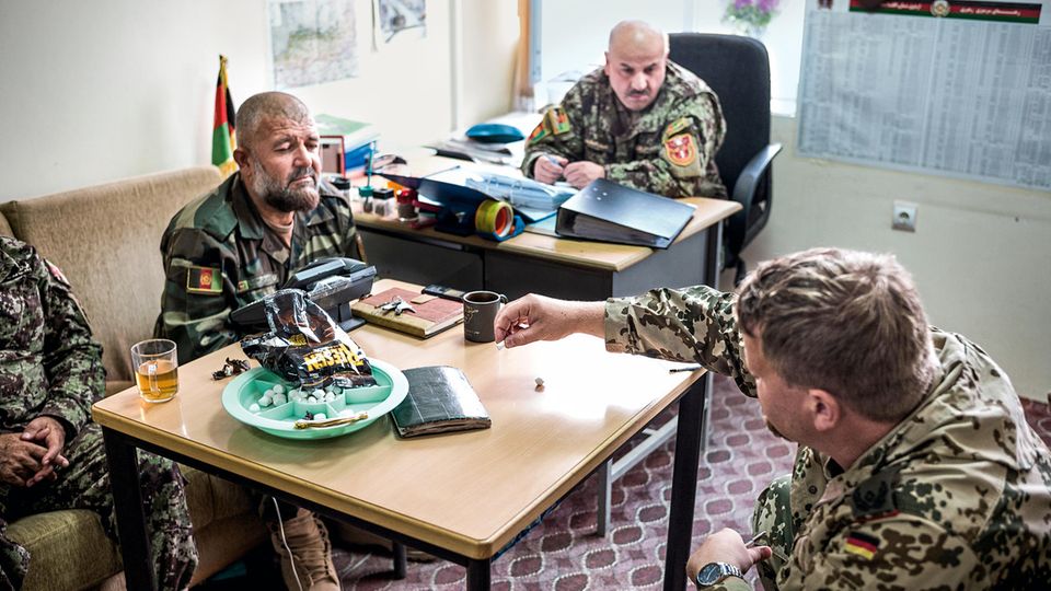 Soldaten am Hindukusch: Zuckerkügelchen gegen Schokopralinen: Kerstens erklärt Oberstleutnant Abdul Latif (M.) ein militärisches Manöver Zuckerkügelchen gegen Schokopralinen: Kerstens erklärt Oberstleutnant Abdul Latif (M.) ein militärisches Manöver