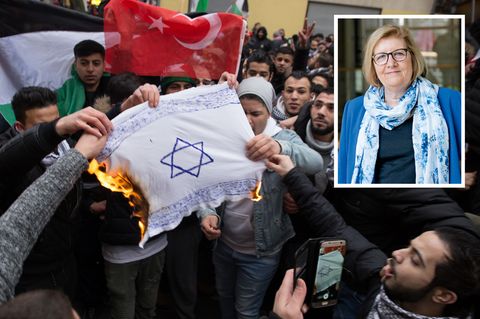 In Berlin-Neukölln zünden Demonstranten eine selbst gemachte Flagge mit Davidstern an