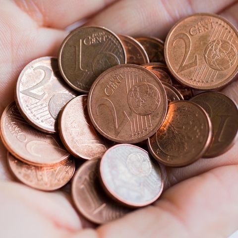 Ein- und Zwei-Cent-Münzen in einer Hand