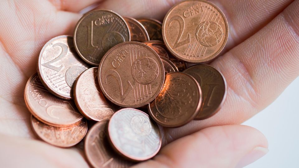 Ein- und Zwei-Cent-Münzen in einer Hand