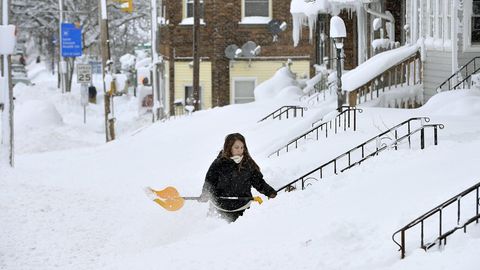 Schneechaos in Erie, Pennsylvania: Eine Frau schippt Schnee vor ihrem Hauseingang