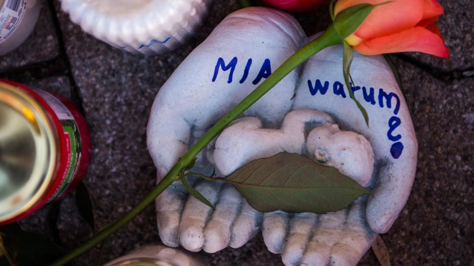 Vor dem Drogeriemarkt in Kandel , in dem eine 15-Jährige erstochen wurde, stehen Kerzen und tönerne Hände mit "Mia - warum?"