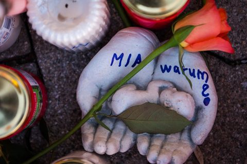 Vor dem Drogeriemarkt in Kandel , in dem eine 15-Jährige erstochen wurde, stehen Kerzen und tönerne Hände mit "Mia - warum?"