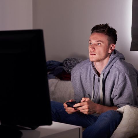 Mann sitzt vor Bildschirm und spielt