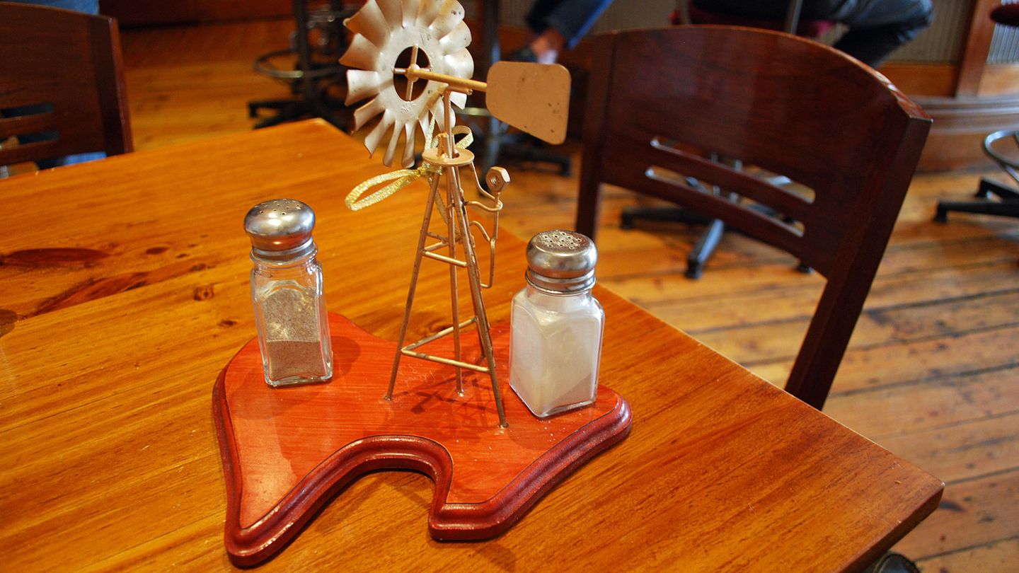 Gewürzhalter auf australische Art: Auf dem Tisch im Austral Inn von Quorn stehen Salz und Pfeffer unter dem Windrad - auf dem Tresen ruht eine Spendenbüchse zugunsten des Royal Flying Doctor Service.