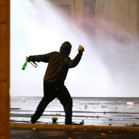 Ein Mann wirft bei Krawallen in Leipzig Flaschen Richtung Polizei - zu Gewalt-Studie