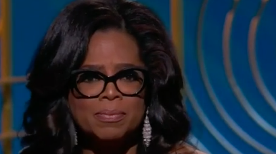 Vor einer blauen Wand mit "Golden Globe Awards"-Logos hält Oprah Winfrey ihre Trophäe in die Kameras