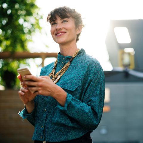 Lächelnde Frau mit Mobiltelefon