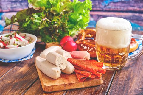 Die wohl bekannteste Spezialität aus München: Weißwurst wird traditionell frühmorgens hergestellt und vormittags als Imbiss auf Märkten und in Wirtshäusern mit süßem Senf, Brezn und Weißbier gegessen. So isst man die Wurst übrigens richtig!