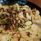 Traditionell werden die Spätzle von Hand geschabt - vom Brett; bis heute gelten die handgeschabten Spätzle als besonderes Gütesiegel. Diese kommen ursprünglich aus dem Schwaben in Württemberg. Schon vor über 400 Jahren aß man sie gerne, vor allem auf dem Land. Dazu wird in Schichten geriebener Emmentaler oder Bergkäse hinzugegeben, der dann schmilzt und die Knöpfle umhüllt, Röstzwiebeln dazu, am bestennoch ein grüner Salat und fertig sind die perfekten Kässpätzle. Wie Kässpätzle perfekt gelingen, können Sie hier lesen!